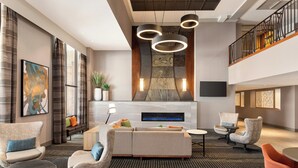 A spacious lobby with a modern fireplace, comfortable seating, and a patterned carpet.