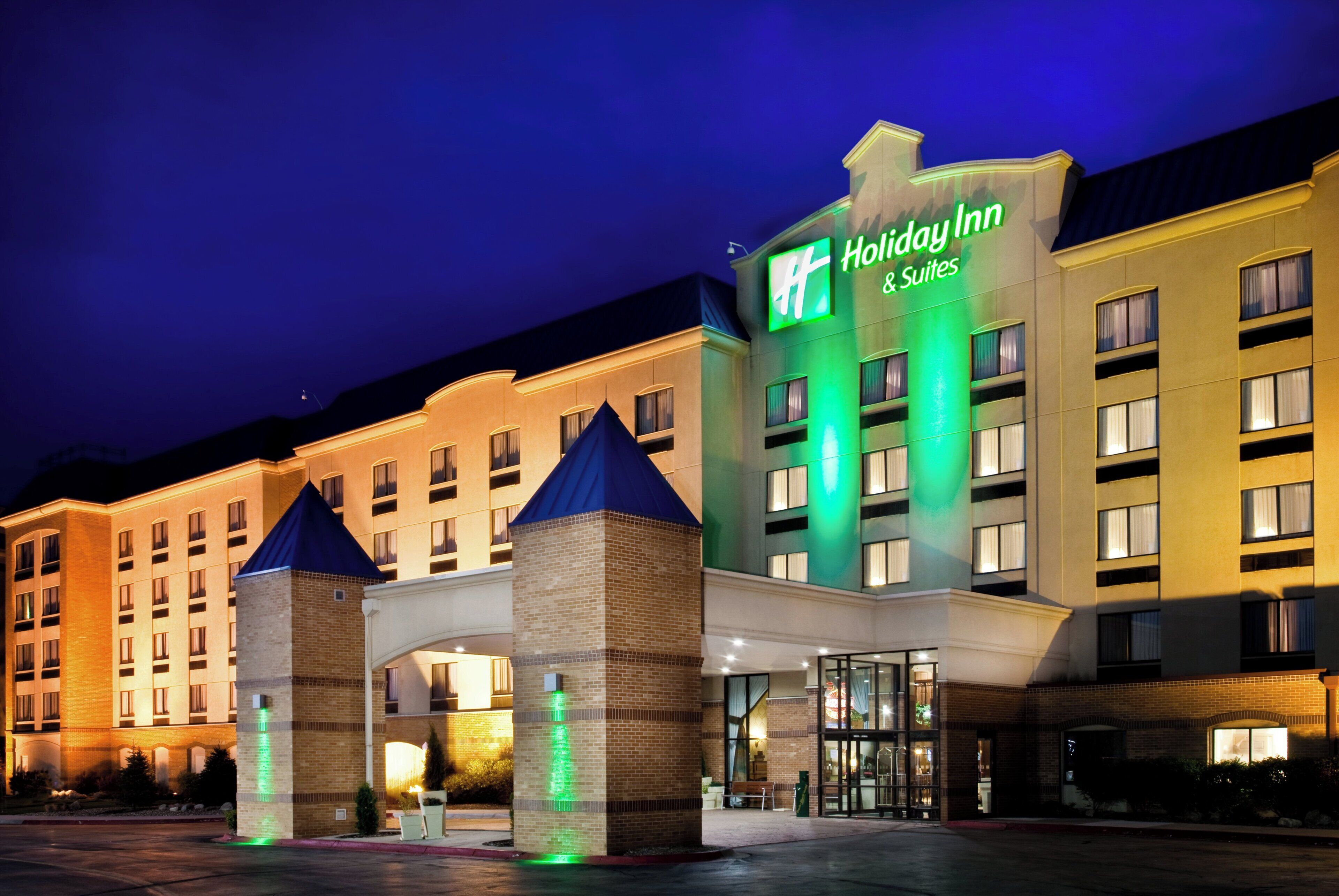 A Holiday Inn hotel with a prominent sign, multiple entry points, and a well-lit facade.