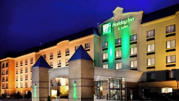 A Holiday Inn hotel with a prominent sign, multiple entry points, and a well-lit facade.