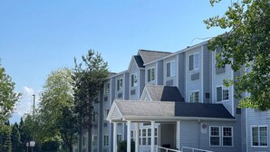 A multi-story residential building with a covered entrance and a wheelchair-accessible ramp. - Baymont Inn & Suites by Wyndham Anchorage Airport (Anchorage)