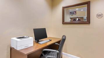 A small office space with a desk, computer, printer, and a chair.