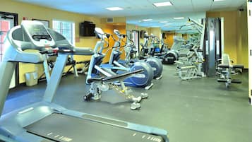 A gym with treadmills, elliptical machines, and weight equipment.