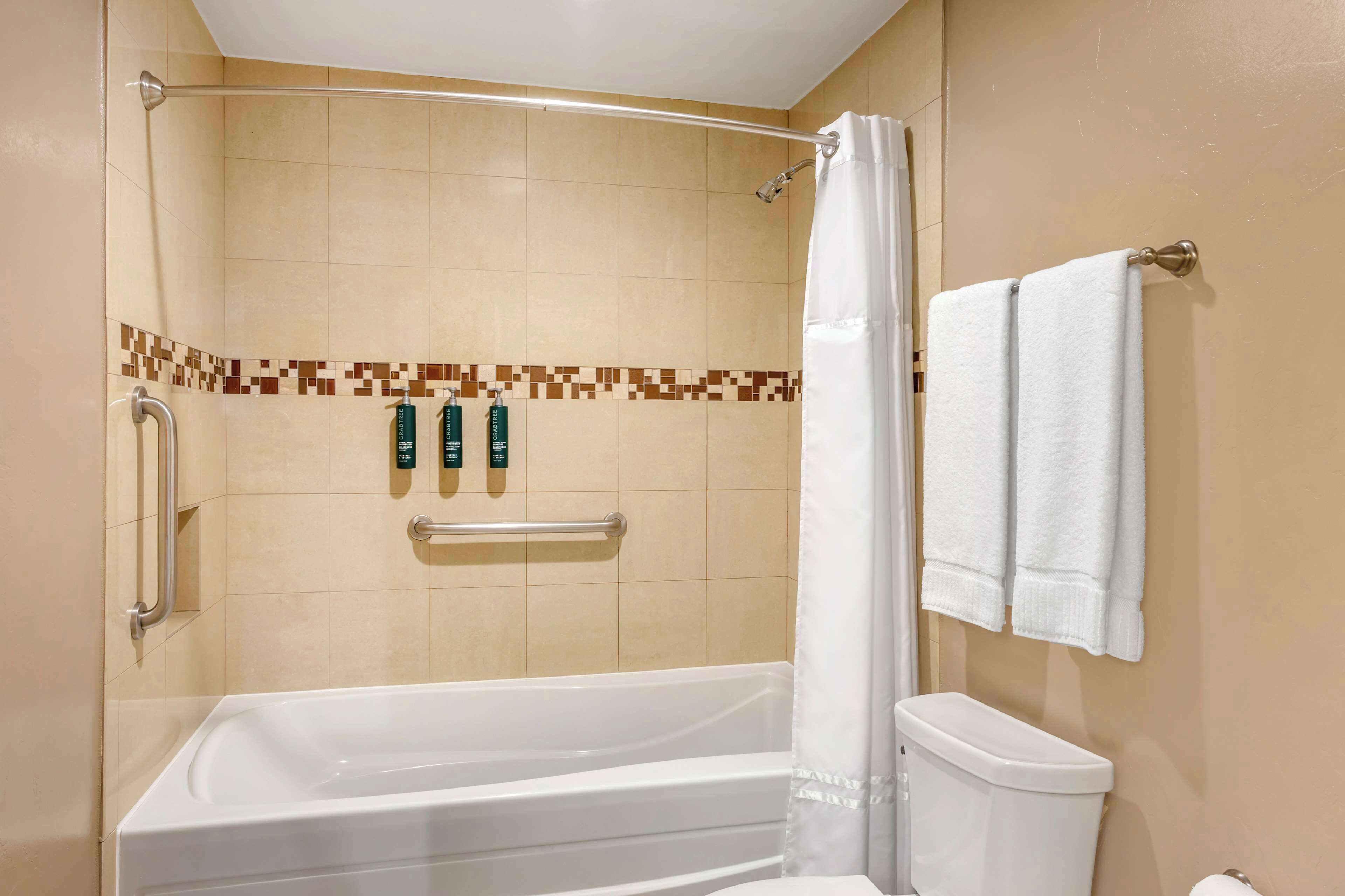 Ein Badezimmer mit Badewanne, Toilette und Duschvorhang.