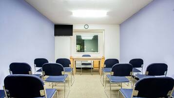A conference room with a long table and eight chairs.