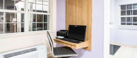 Um espaço de escritório em casa com escrivaninha, cadeira e computador.
