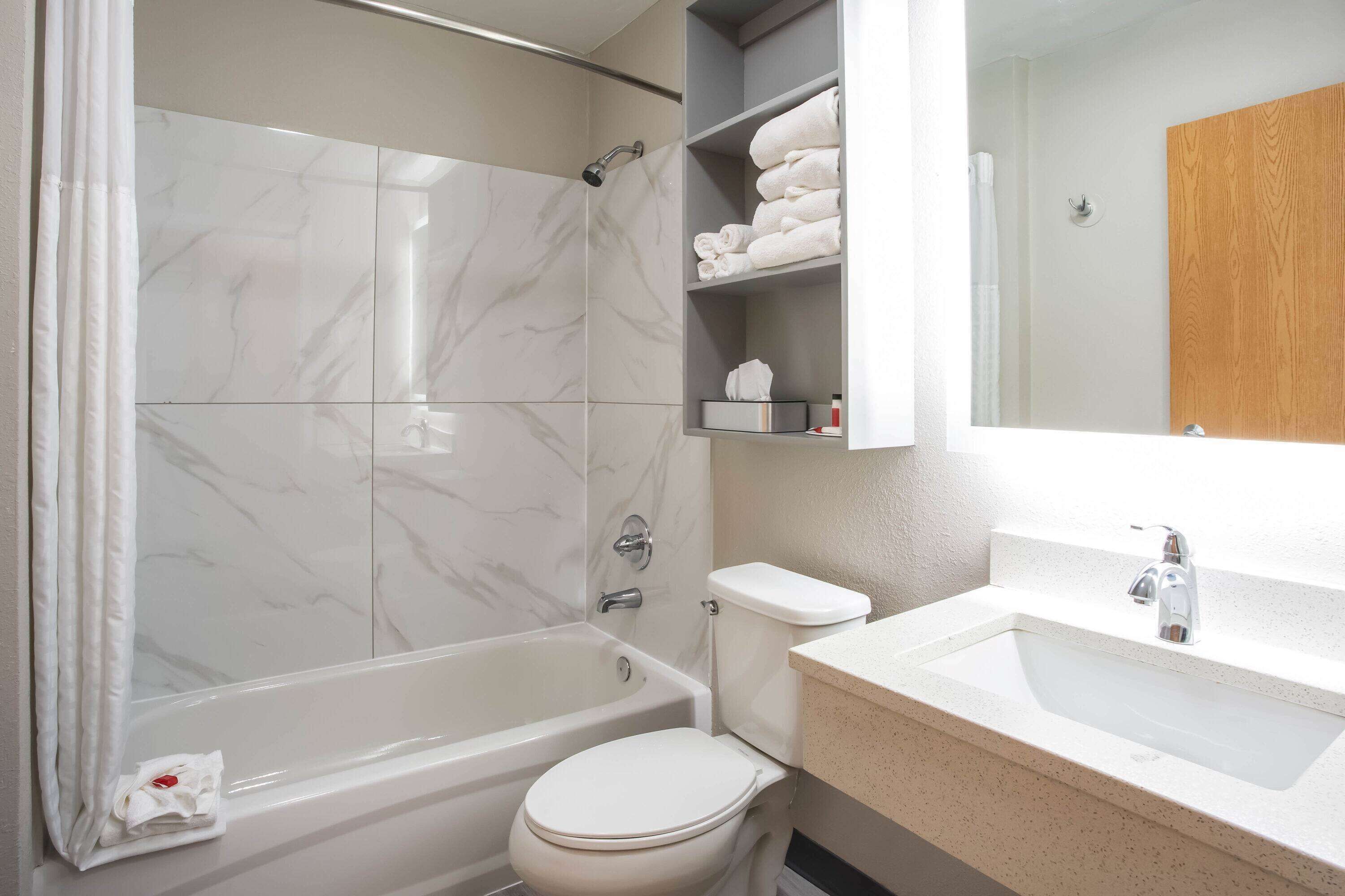 A bathroom with a bathtub, toilet, and sink.