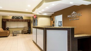 Un área de recepción con mostrador, asientos y un reloj.