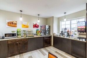 A modern kitchen with a microwave, coffee maker, and a fruit display. - Quality Inn & Suites North Lima - Boardman (North Lima)