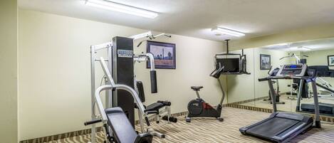 A hotel gym with a treadmill, elliptical, and weight machine.