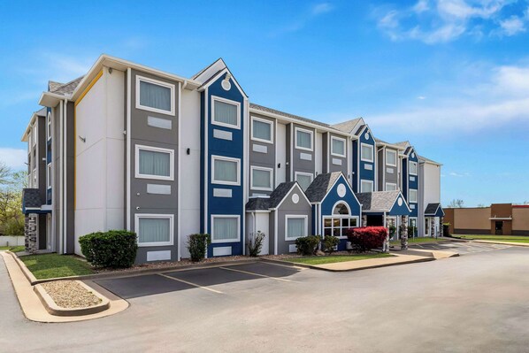 A multi-story hotel with a modern design, featuring a parking lot and well-maintained landscaping. - Microtel Inn & Suites by Wyndham Tulsa/Rt 66 Near Casino (Tulsa)