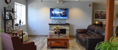 A living room with a fireplace, a television, a sofa, and a chair.
