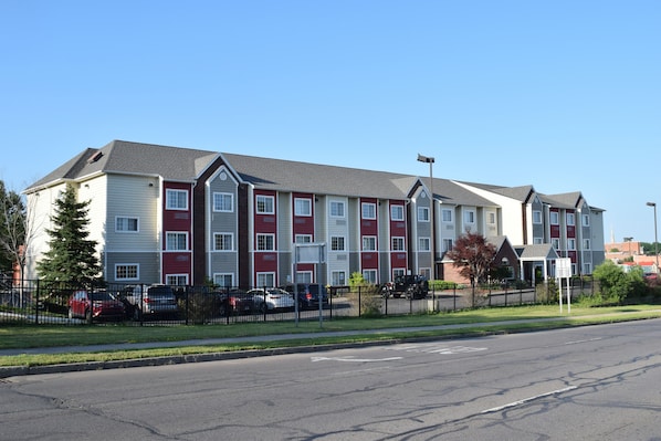 A multi-story apartment building with a uniform exterior design, featuring a mix of red and white colors.