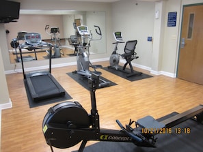 A gym with various exercise equipment including treadmills, stationary bikes, and elliptical machines.
