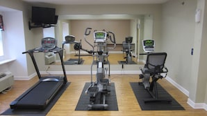 A fitness room with treadmills, an elliptical, and a stationary bike. - Inn at the Finger Lakes (Auburn)
