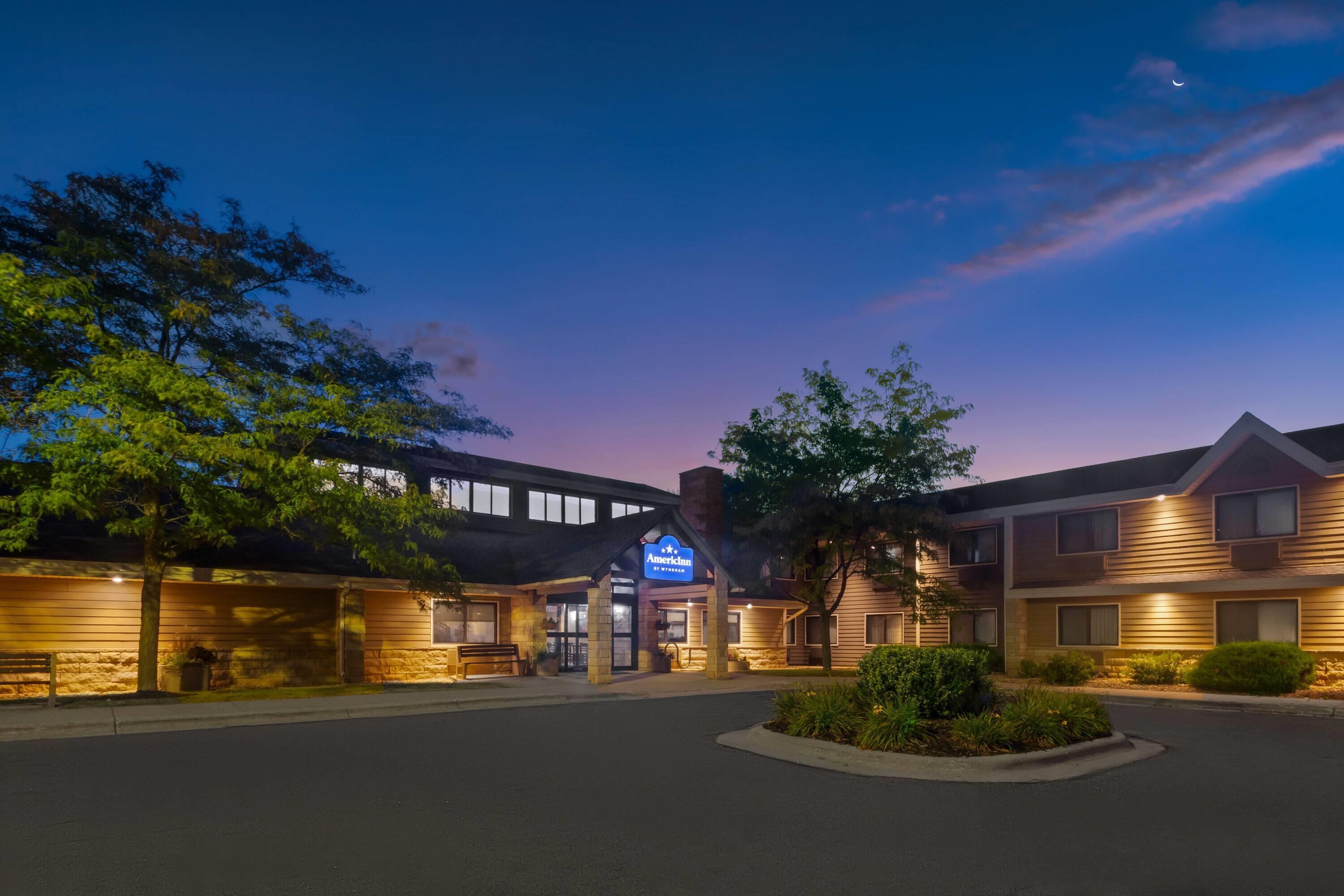 A hotel with a modern design, featuring a prominent entrance and a landscaped front yard.