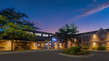 A hotel with a modern design, featuring a prominent entrance and a landscaped front yard.