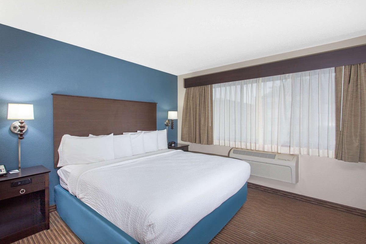 Escritorio, cortinas blackout y tabla de planchar con plancha