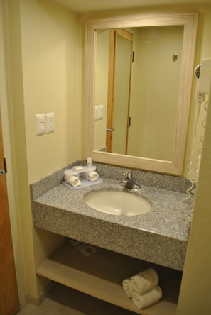 A bathroom with a granite countertop, a white sink, a mirror, and a towel rack. - Holiday Inn Express Toluca by IHG (Toluca)