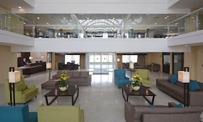 A spacious lobby with a high ceiling, seating areas, and a reception desk. - Holiday Inn Express Toluca by IHG (Toluca)