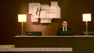 Una recepción con un cartel que dice 'Holiday Inn Express' y dos lámparas a cada lado.