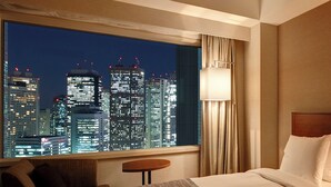A hotel room with a large window offering a cityscape view at night. - Century Southern Tower Hotel (Tokyo)