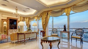 Ein luxuriöses Zimmer mit großem Fenster und Blick auf die Stadt, einer Kandelaber und aufwendigen Möbeln.