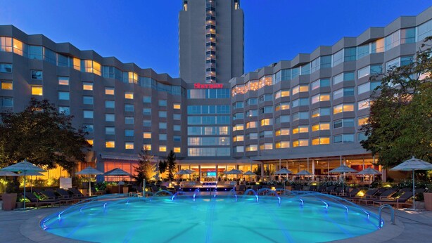 Ein Sheraton Hotel mit Schwimmbad, Außenbereich und Bar/Lounge.