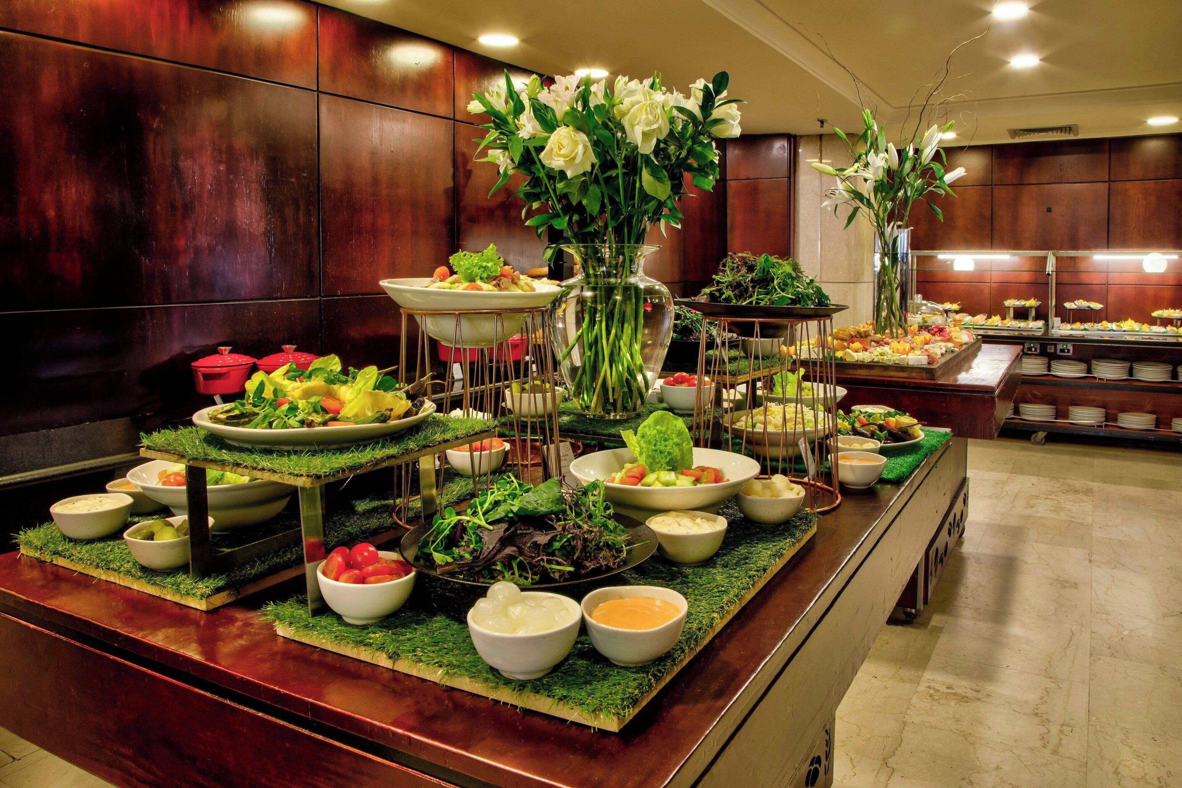 A buffet setup with various dishes and a floral centerpiece.