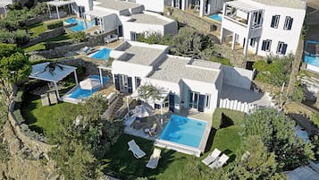 A resort with multiple swimming pools, white buildings, and lush greenery.