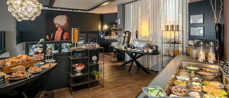 Un desayuno tipo buffet moderno con diversas opciones de comida, una estación de café y un cuadro decorativo.