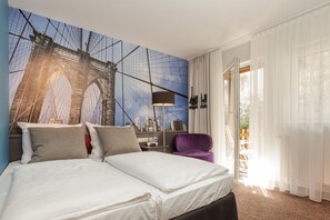Habitación de hotel con una cama, un sillón púrpura, una lámpara y un mural de un puente.