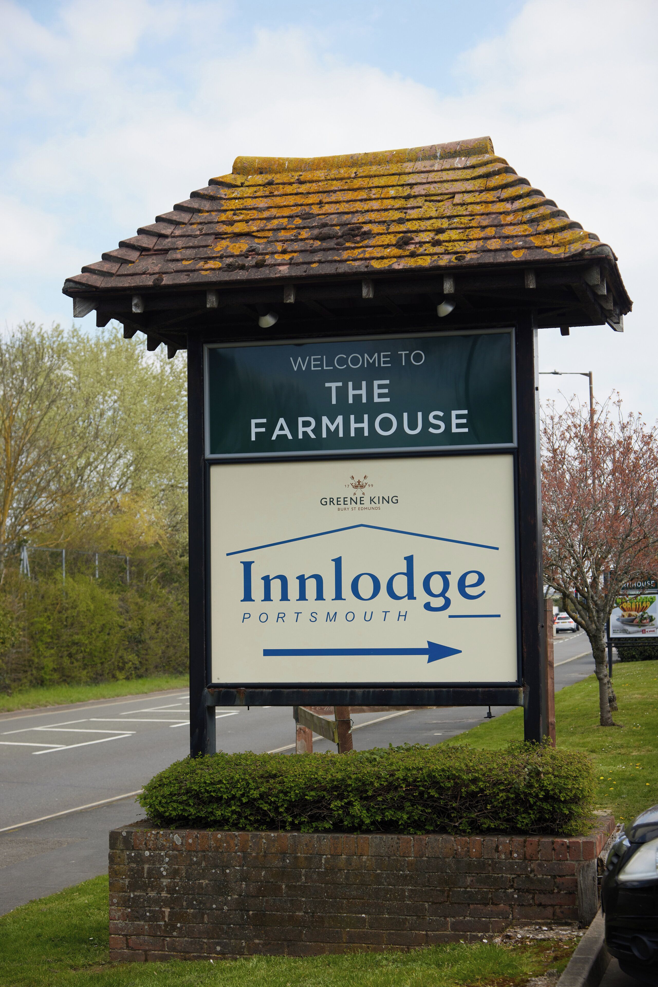 A welcome sign for the Inn Lodge at the Farmhouse, indicating the direction to the property.