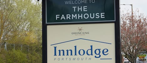 Señal de bienvenida del Inn Lodge en Farmhouse, indicando el camino hacia la propiedad.