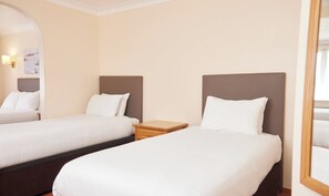 A hotel room with two single beds, a wooden nightstand, and a mirror. - Farmhouse Innlodge by Greene King Inns (Portsmouth)