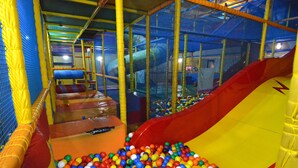 Un área de juegos interior con tobogán y piscina de pelotas.