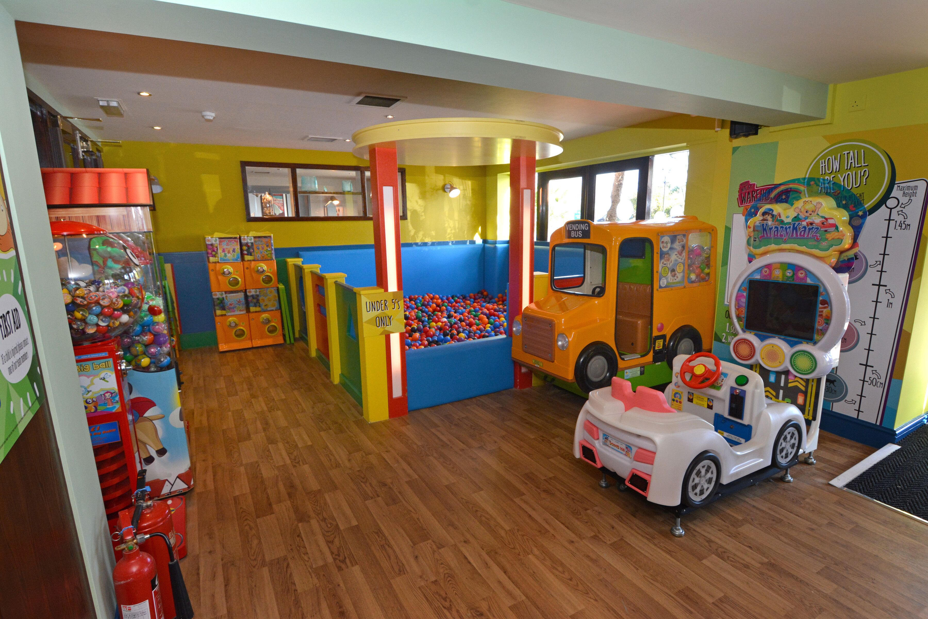 A children's play area with a ball pit, a toy bus, and a toy car.