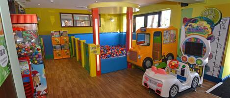 A children's play area with a ball pit, a toy bus, and a toy car.