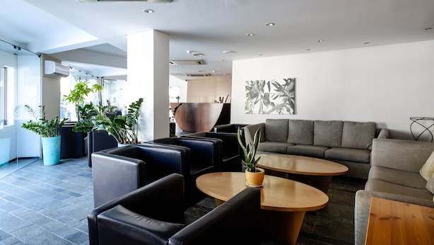 Ein stilvoller Lounge-Bereich mit Ledersofas, Holztischen und Zimmerpflanzen.