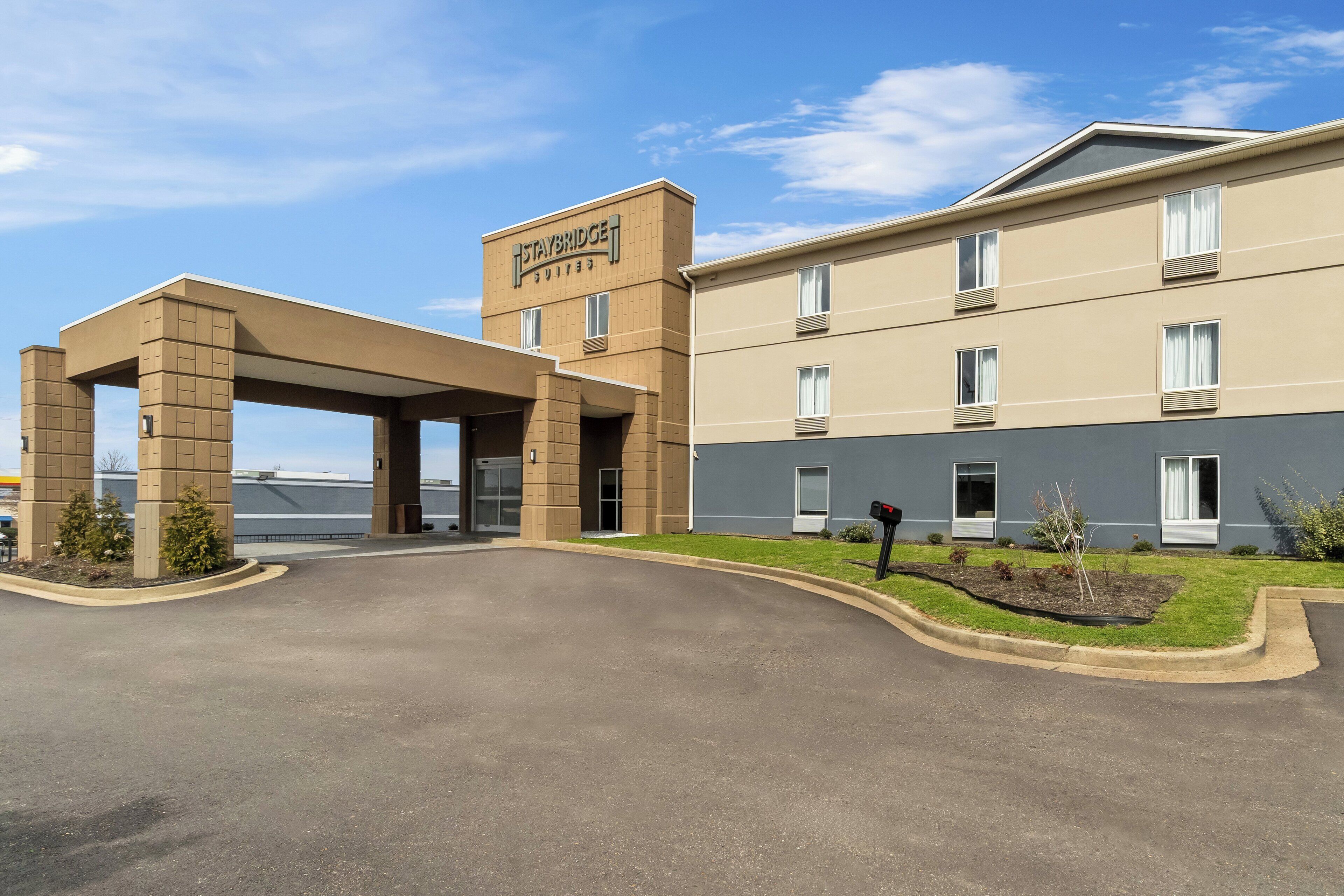 Staybridge Suites -hotelli, jossa on katettu sisäänkäynti, pysäköintialue ja avoin taivas.