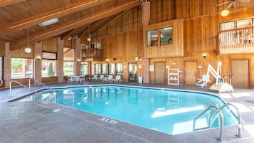 Una piscina techada, sillones reclinables de piscina