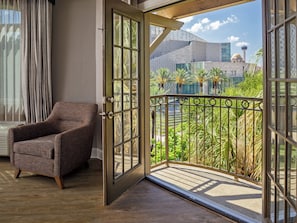 An open door leading to a balcony with a view of a modern building and palm trees. - Hotel Indigo San Antonio Riverwalk by IHG (San Antonio)