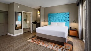 A hotel room with a large bed, a mirror, a bathroom with a shower, and a nightstand with a lamp. - Hotel Indigo San Antonio Riverwalk by IHG (San Antonio)