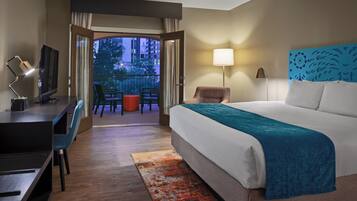 Ein Hotelzimmer mit Bett, Schreibtisch, Stuhl und Blick ins Freie.