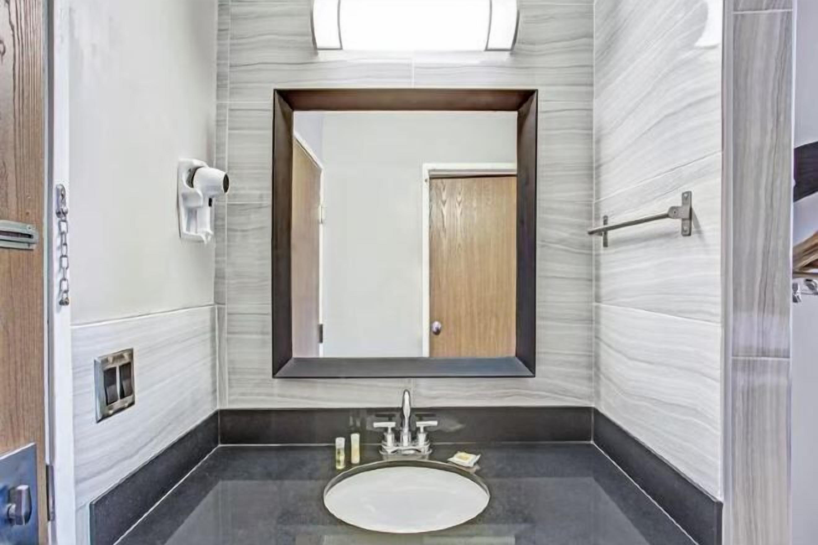 Badkamer | Een bad/douchecombinatie, gratis toiletartikelen, een haardroger