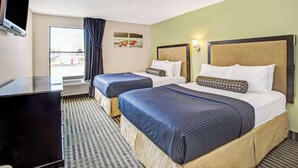 Hotellihuone, jossa on kaksi sänkyä, taulutelevisio, ikkuna verhoilla ja taideteoksia seinällä.