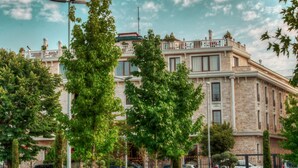 Un edificio grande e histórico de estilo arquitectónico clásico, rodeado de céspedes y árboles bien cuidados.