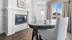 Un comedor con una mesa redonda, sillas, chimenea y vistas al exterior.