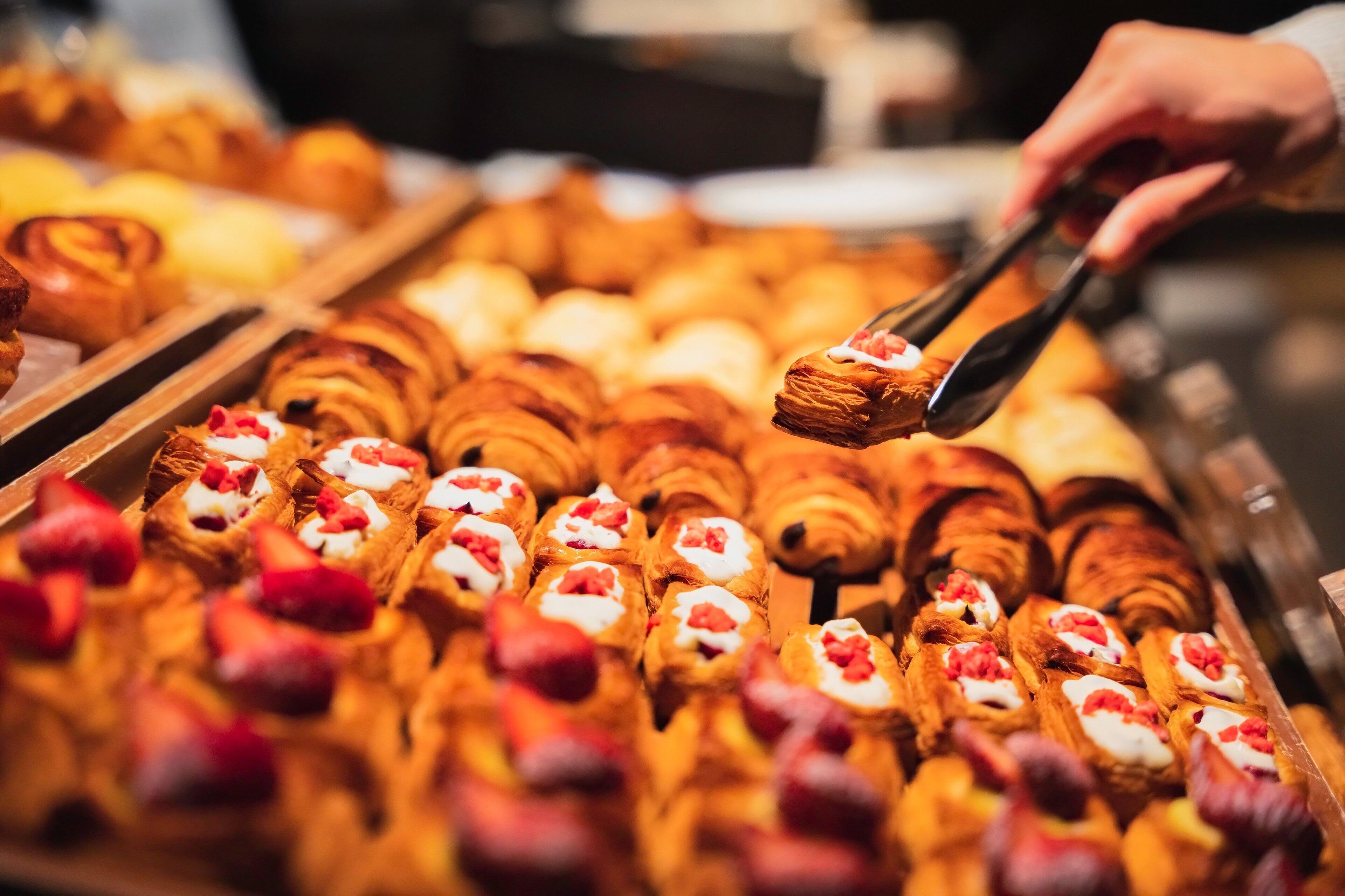 A variety of pastries, including croissants and danishes, arranged on a tray.