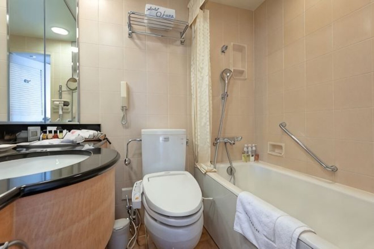 Un baño con inodoro, lavamanos, bañera y ducha.