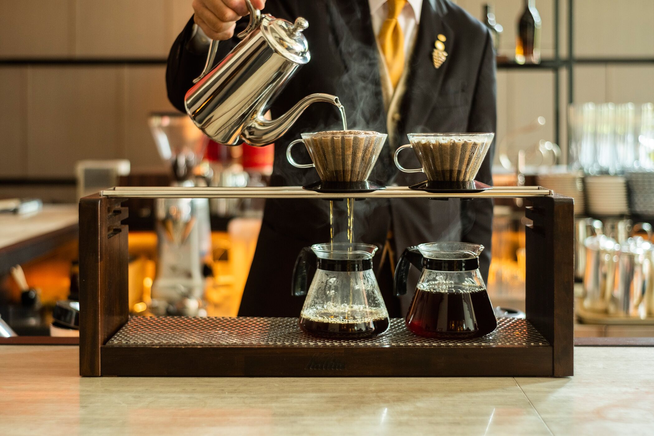 En barista häller kaffe i en kopp vid en kaffestation.